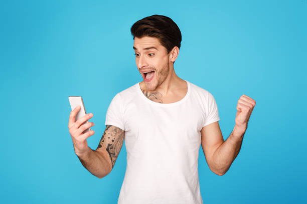 istock Overjoyed man looking at cellphone and celebrating victory 1179521634