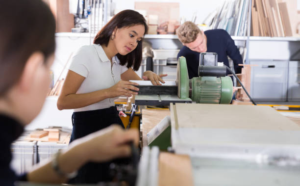 istock Female student sanding details of architectural model on machine 1179523009
