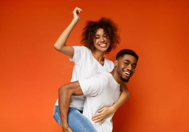 istock Cheerful african man riding his girlfriend on back 1179523262
