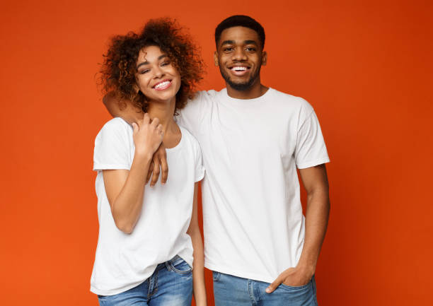 istock Happy african millennials embracing on orange background 1179523599