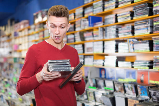 istock Serious man attentively reading contents  at  DVD in store 1179523701