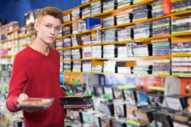 istock Guy holding CD in shop 1179523779