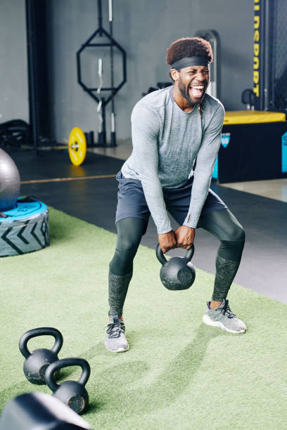 istock Sportsman doing deep squat with kettlebell 1179525783