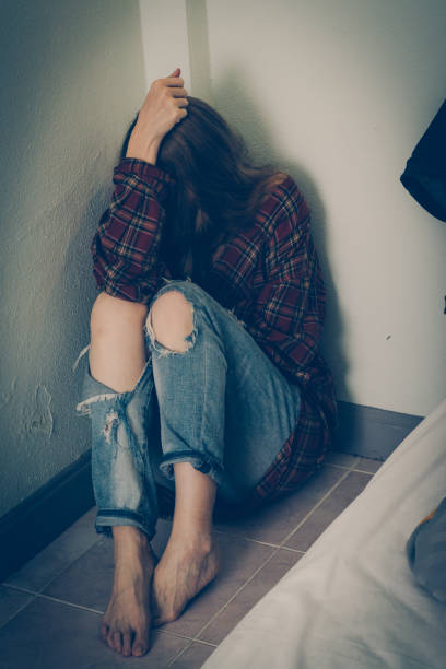 istock Depressed woman sitting on the floor 1179526366