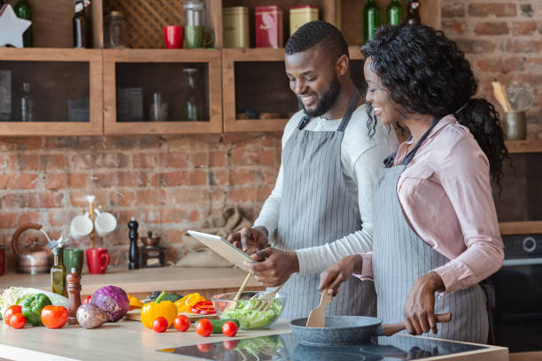 istock Lovely couple using digital tablet while cooking meal 1179526798