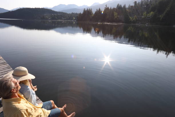 istock Couple relax on lakeside pier at sunrise 1179527100