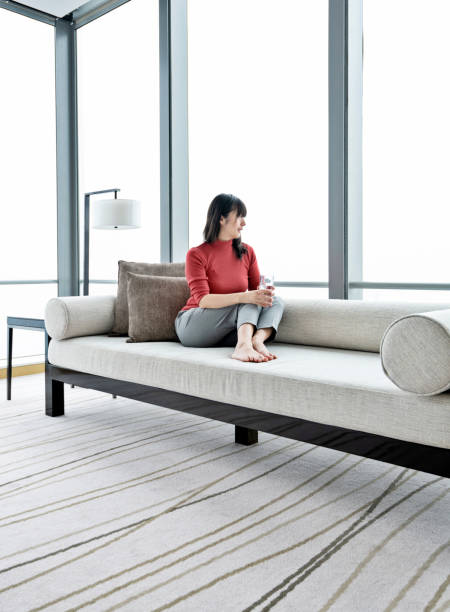 istock Woman sitting on sofa and drinking water 1179527355