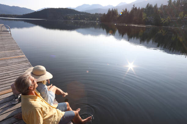 istock Couple relax on lakeside pier at sunrise 1179527729