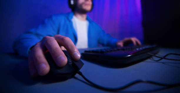 main mâle utilisant la souris d'ordinateur jouant des jeux en ligne - souris dordinateur photos et images de collection