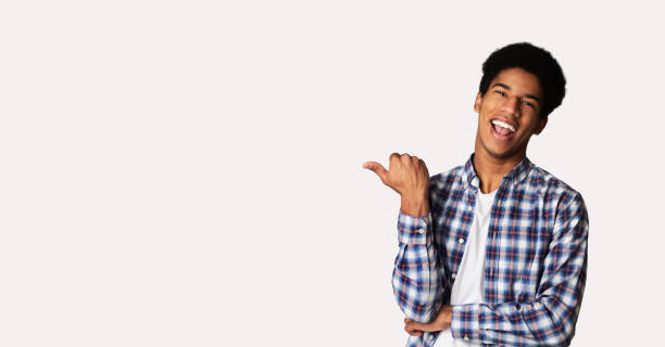 istock Cheerful teenage guy pointing aside at copy space 1179527957