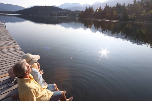 istock Couple relax on lakeside pier at sunrise 1179528518