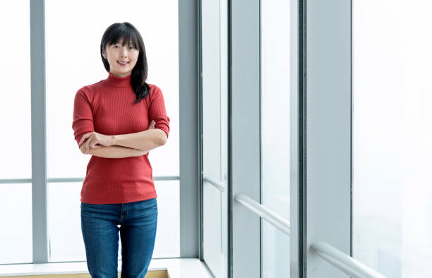 istock Smiling woman standing in front of window 1179528891