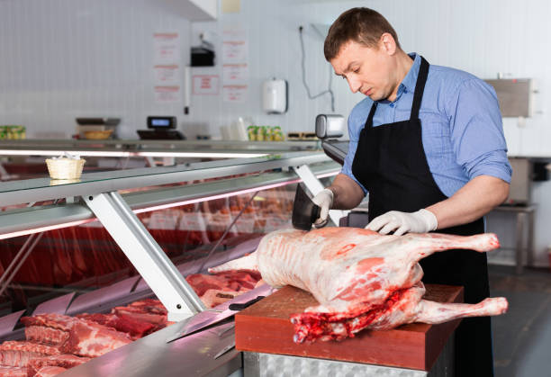 istock Skillful butcher processing carcase of young lamb for sale at butchery 1179529547