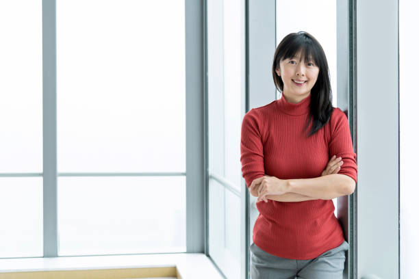 istock Smiling woman standing in front of window 1179531215