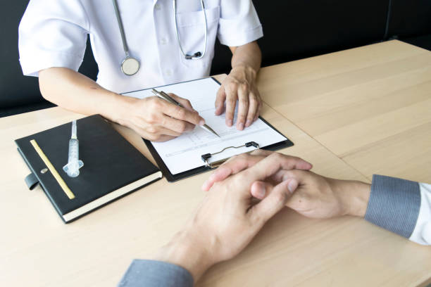 istock Midsection Of Doctor And Patient Discussing On Table 1179531866