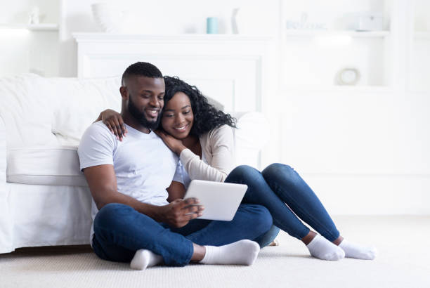 istock African couple using digital tablet together while sitting at home 1179532221