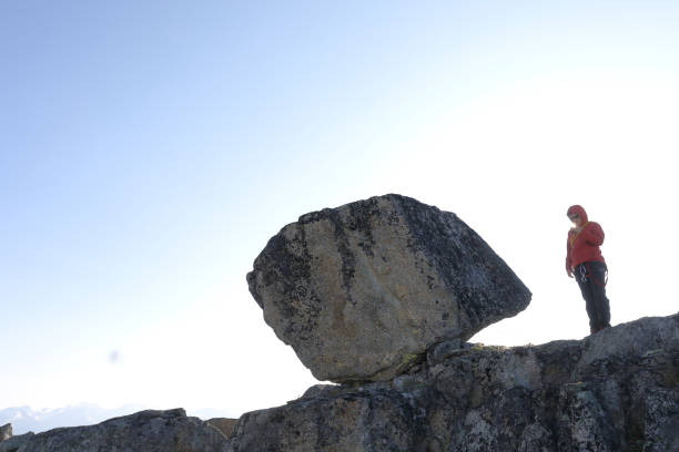 istock Mountaineer stands on top of cliff with camera 1179532437
