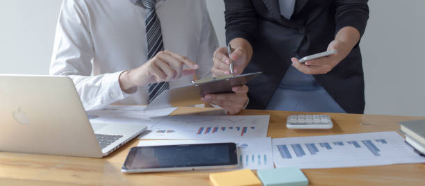 istock Midsection Of Business Colleagues Analyzing Paperwork On Desk In Office 1179532851