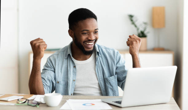 istock Black employee looking at laptop screen and celebrating success 1179532947