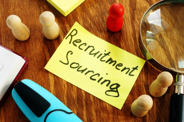 istock Recruitment Sourcing sign and magnifying glass on desk. 1179535196