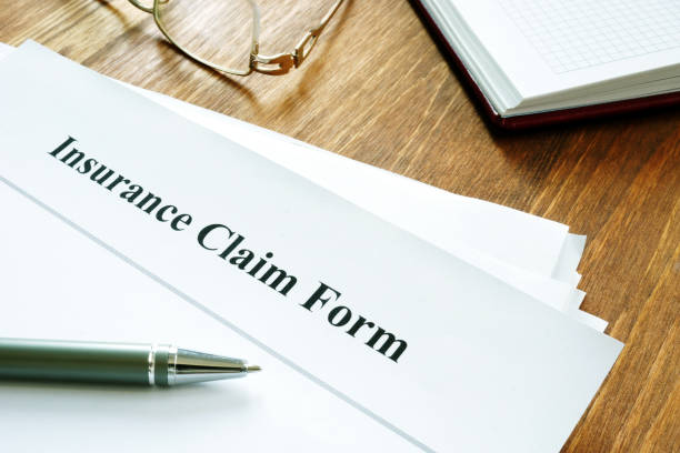 istock Insurance claim form with pen on wooden surface. 1179535407