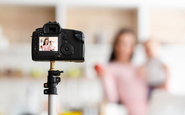 istock Mother with toddler recording video for webinar, kitchen interior 1179535503