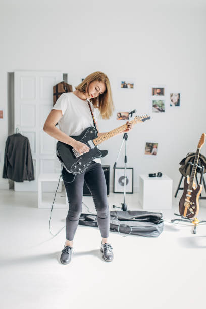 istock Beautiful lady playing guitar in music studio alone 1179535515