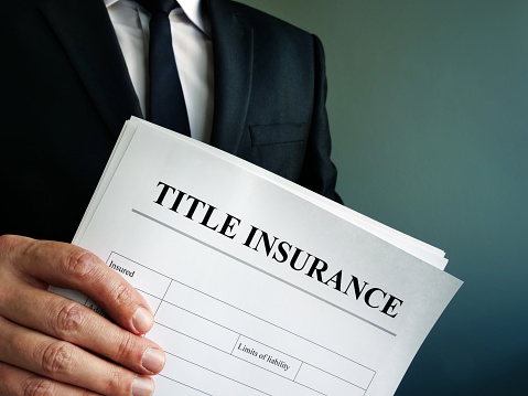 Title Insurance agreement in the hands of a businessman.