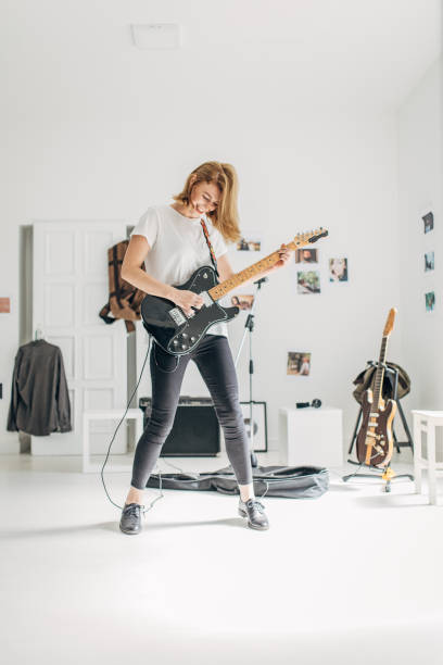 istock Beautiful woman playing guitar in music studio alone 1179535657