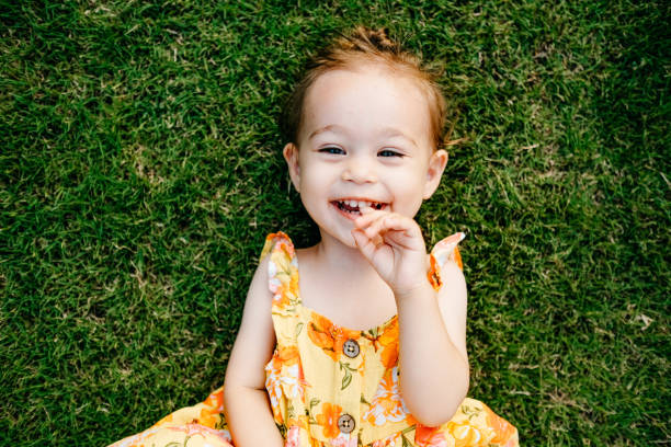 istock Happy Smiling Little Girl Lying On Grass 1179536199