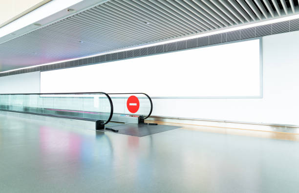 Blank billboard on the wall of pedestrian walkway Blank billboard on the wall of pedestrian walkway. airport travelator stock pictures, royalty-free photos & images