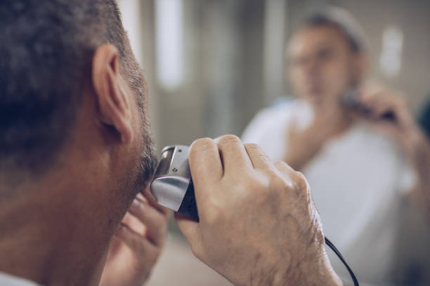 istock The older man trims his beard himself 1179540891