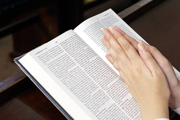 istock Female hands praying on bible 117954304