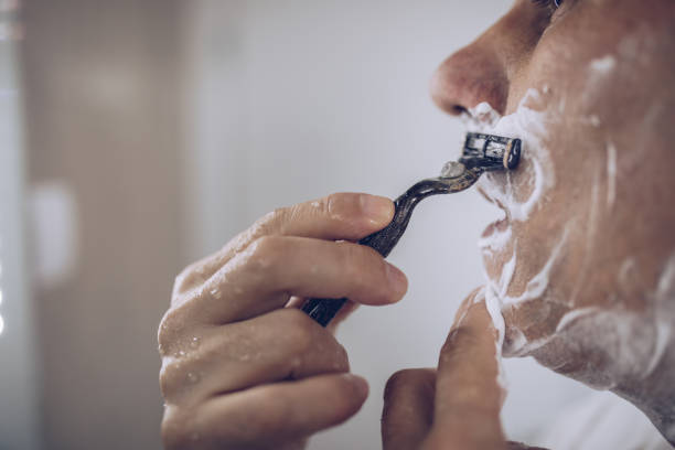adult man shave his beard in domestic bathroom - shaving men shaving cream mirror imagens e fotografias de stock