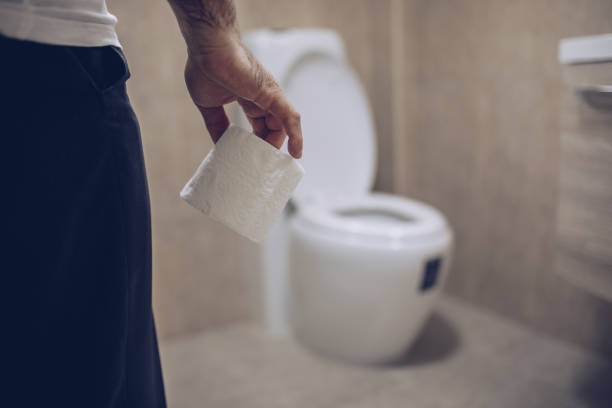 istock An elderly man holds toilet paper in his hand 1179543553