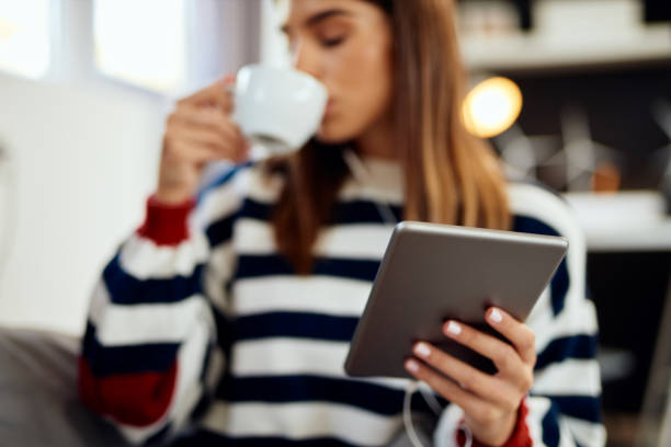 istock Woman using tablet and drinking coffee in bed. 1179544033