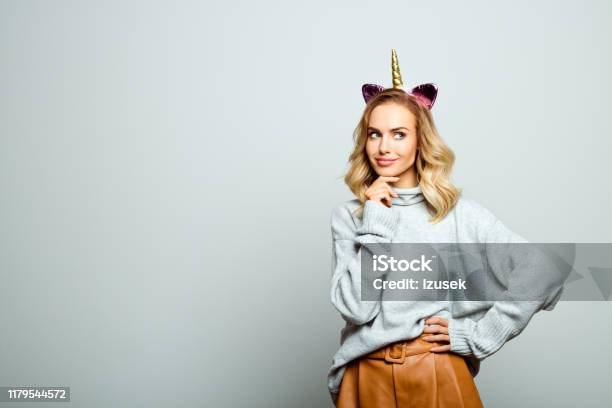 Studio Portrait Of Beautiful Woman With Unicorn Headband Stock Photo - Download Image Now