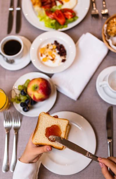 istock Young woman spreading jam on a toast 1179546340