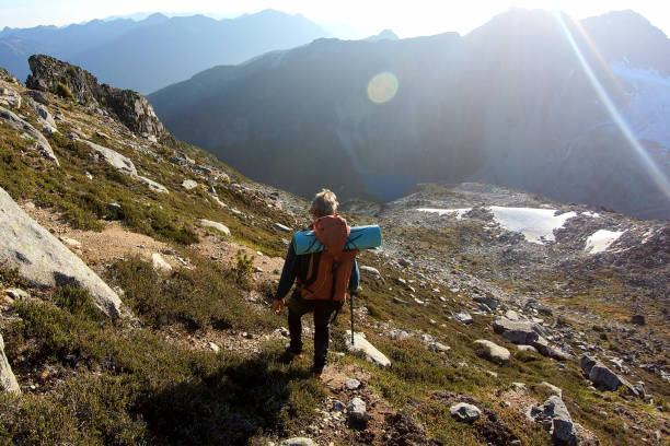 istock Male hiker crosses mountainside at sunrise 1179546475