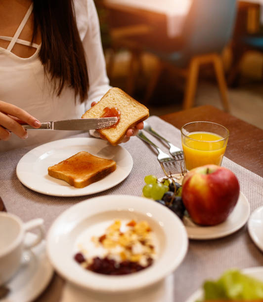 istock Young woman spreading jam on a toast 1179546494