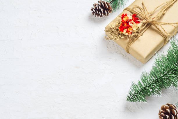 istock Handmade Christmas gift box with pine tree and pine cone on white snow wood background with copy space for your text. 1179546748