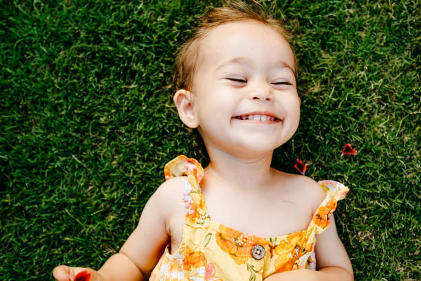 istock Happy Smiling Little Girl Lying On Grass 1179547229