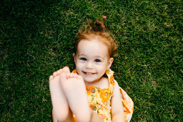 istock Happy Smiling Little Girl Lying On Grass 1179548083