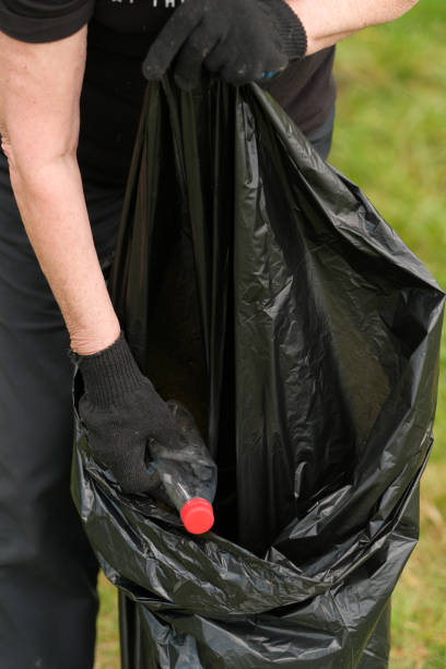 istock hands putting household waste into small bin bag 1179548170