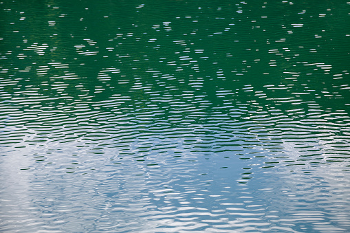 Close up detail of water surface with ripples on it.