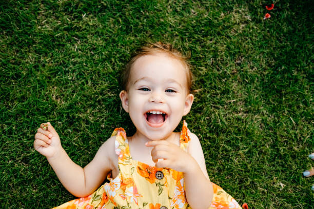 Happy Smiling Little Girl Lying On Grass