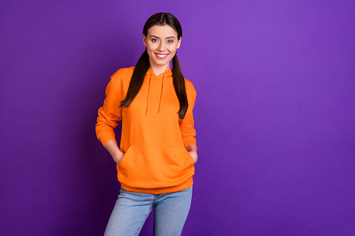Portrait of positive cheerful youth teen girl feel content have fun with her friends on free time, wear sportswear isolated over violet purple color background