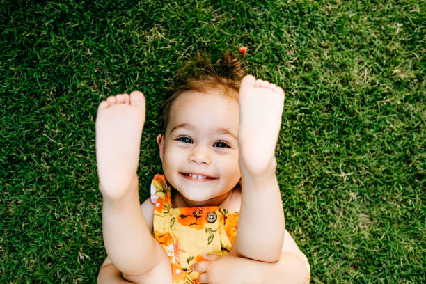 istock Happy Smiling Little Girl Lying On Grass 1179552583