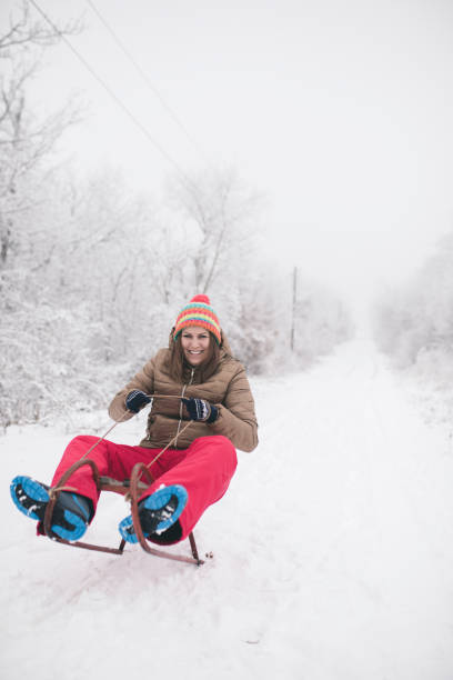 istock young woman sledging in deep snow and have fun 1179552734