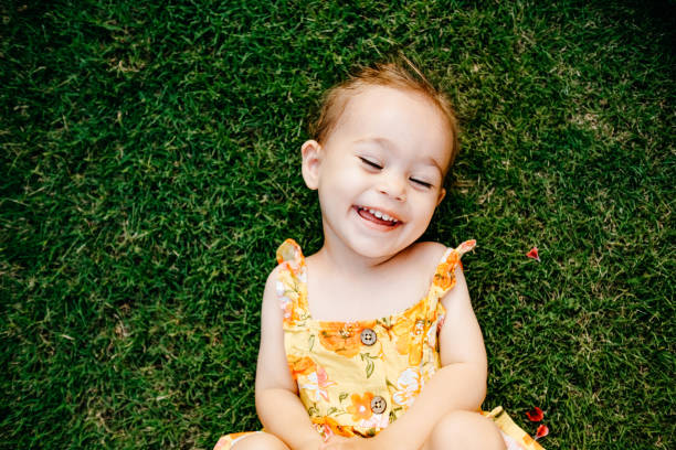 istock Happy Smiling Little Girl Lying On Grass 1179554077